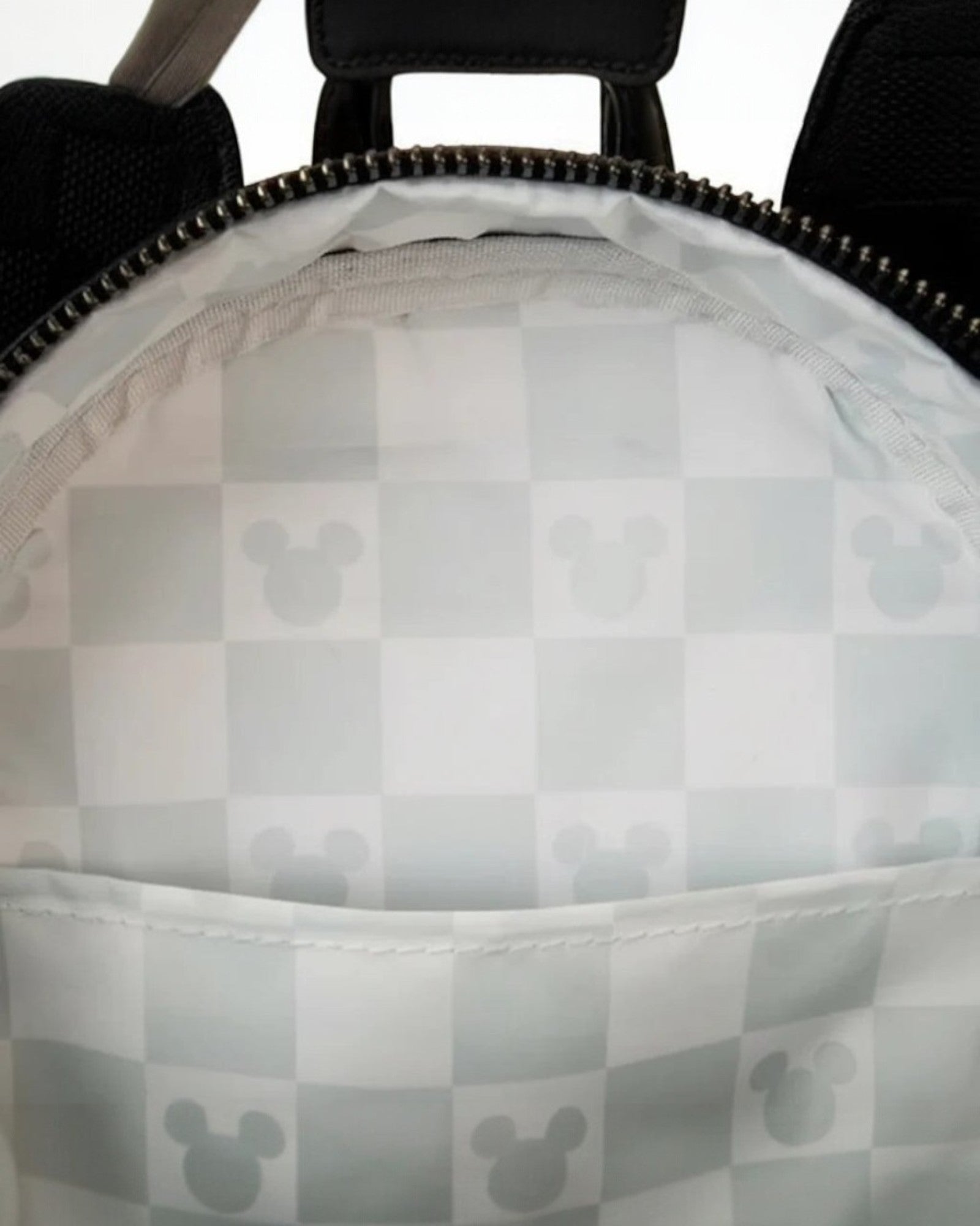 Close-up of a gray checkered bag interior with a zipper.