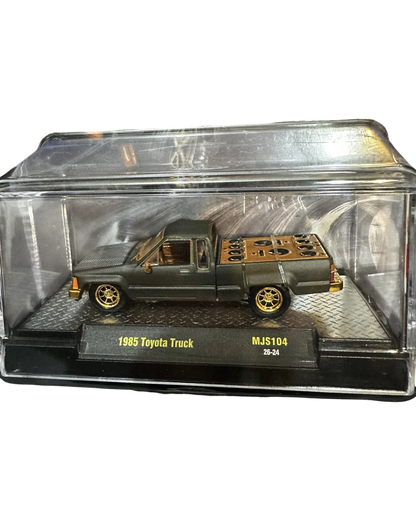 More Than Diecast 1:64 scale matte grey 1985 Toyota pickup truck chase variant with gold wheels in display case