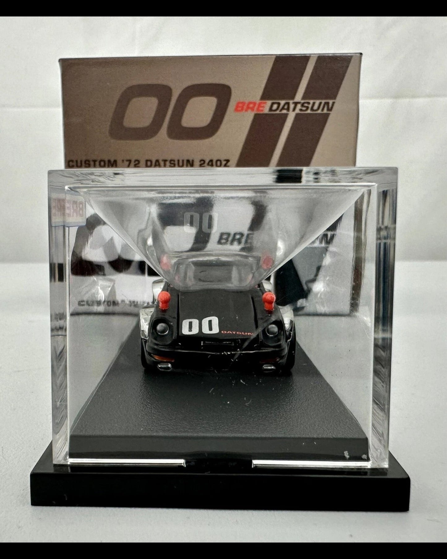 More Than Diecast Hot Wheels RLC Custom 72 BRE Datsun 240Z in a clear display case, rear view showing 00 racing livery.