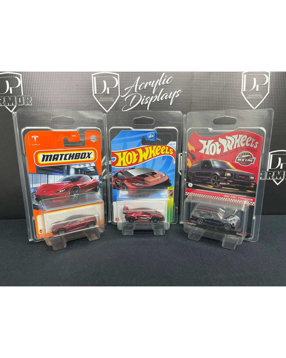 More Than Diecast Diamond Protector 2.0 cases holding three carded Hot Wheels and Matchbox diecast toy cars.