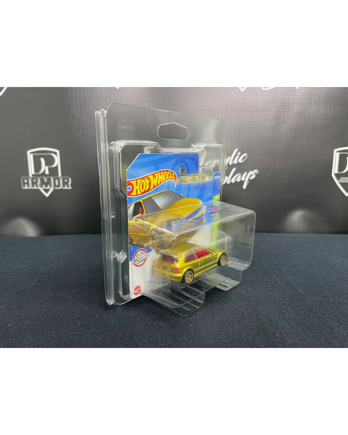 More Than Diecast Diamond Short Card Protector holding a yellow Hot Wheels car in clear PVC packaging, side view.