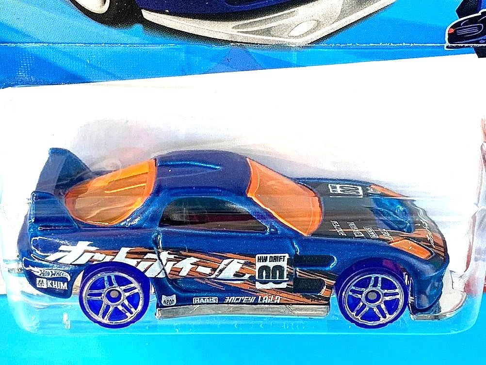 More Than Diecast Hot Wheels 24/Seven 1:64 scale die-cast car in metalflake blue with orange windows and drift decals.
