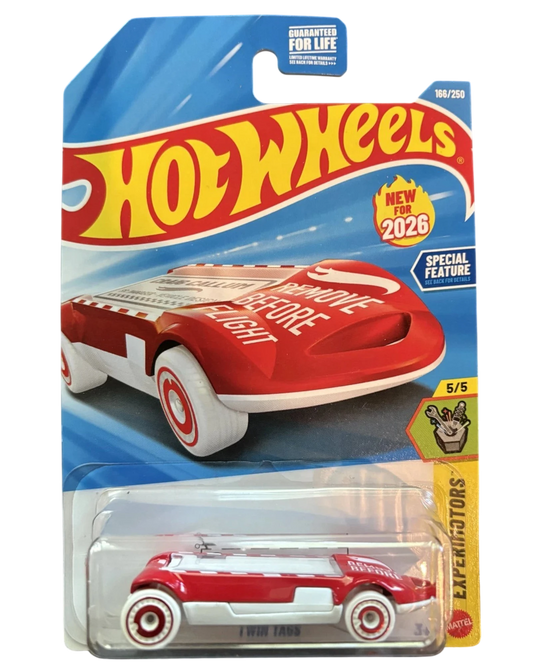 More Than Diecast red and white Twin Tags Hot Wheels toy car with "REMOVE BEFORE FLIGHT" text.