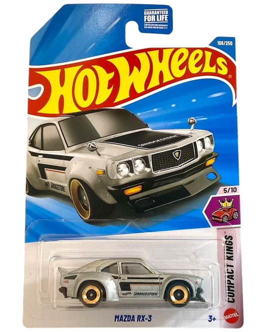 More Than Diecast 2026 Hot Wheels Mazda RX-3 diecast car, silver with black racing stripes and gold rims.