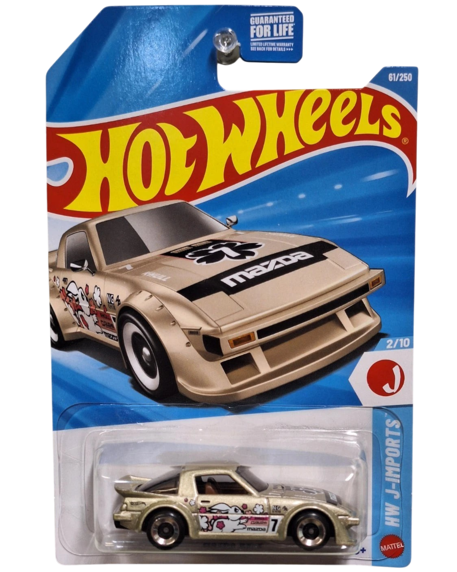 More Than Diecast Hot Wheels 2026 Mazda RX-7 die-cast car in gold with J-Imports graphics on blister card packaging.