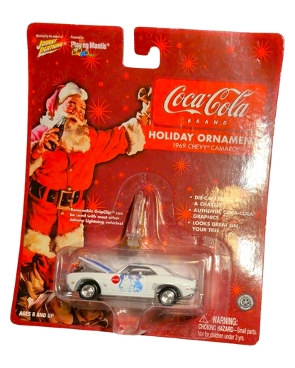 More Than Diecast Coca-Cola 1969 Chevy Camaro holiday ornament. White die-cast car with blue stripes and Coca-Cola graphics, featuring Santa Claus.